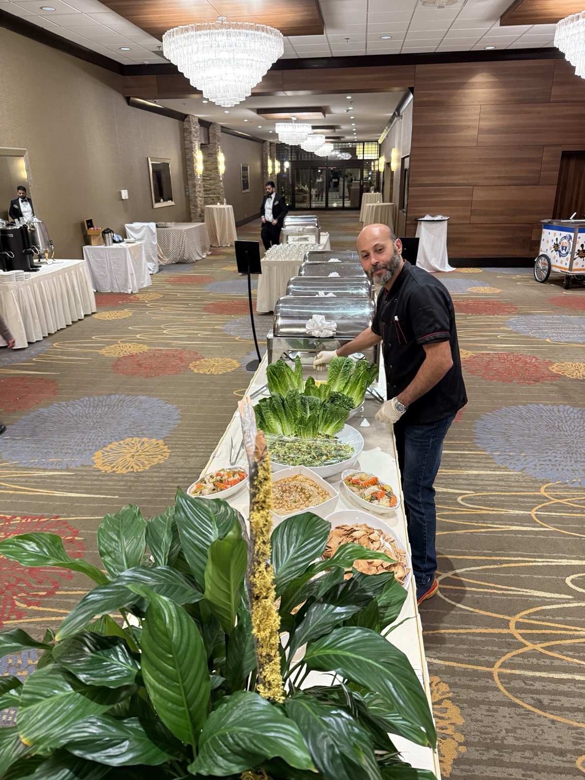 Catering team setting up a long buffet at an indoor event