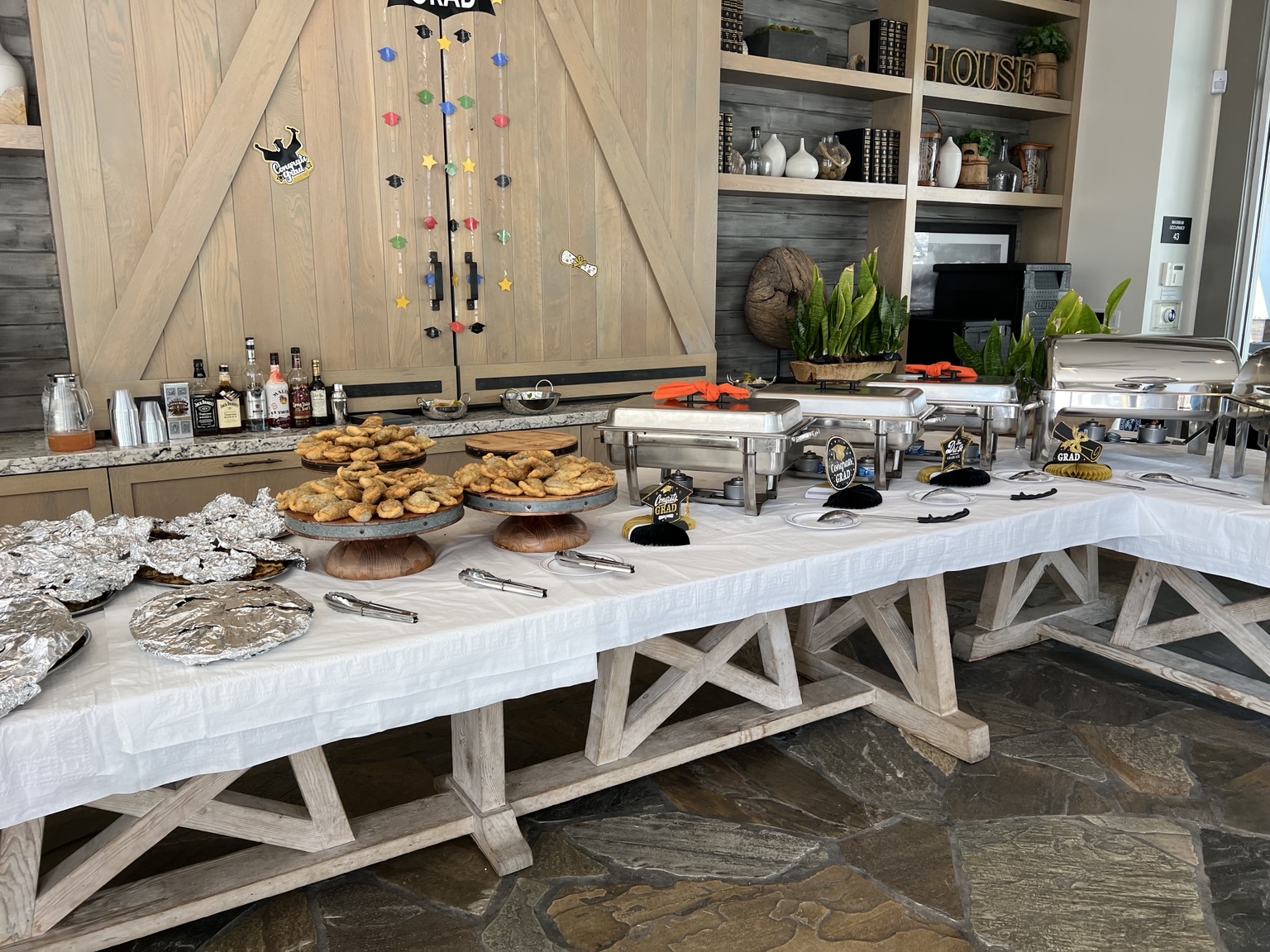 Buffet with serving trays and platters set up for a graduation gathering